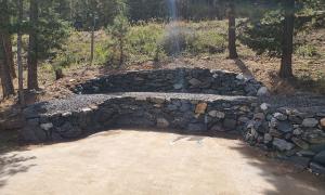 After photo of a sloped yard with a retaining wall. 