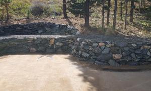After photo of a sloped yard with a retaining wall. 