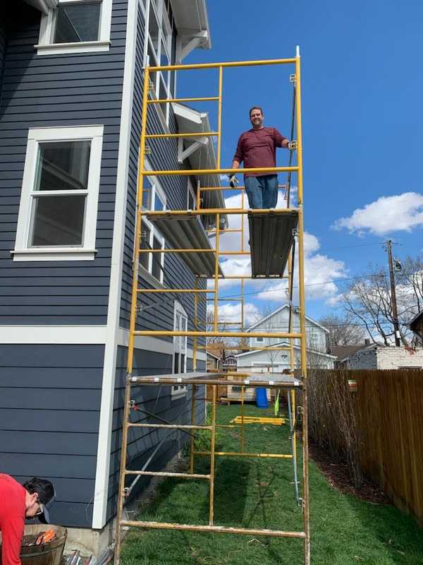 Photo of Shane on a scaffolding.