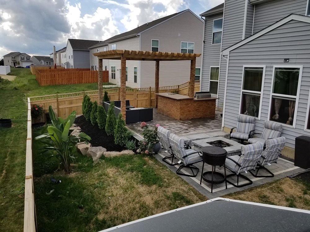backyard featuring pinetrees,chairs and luncrete